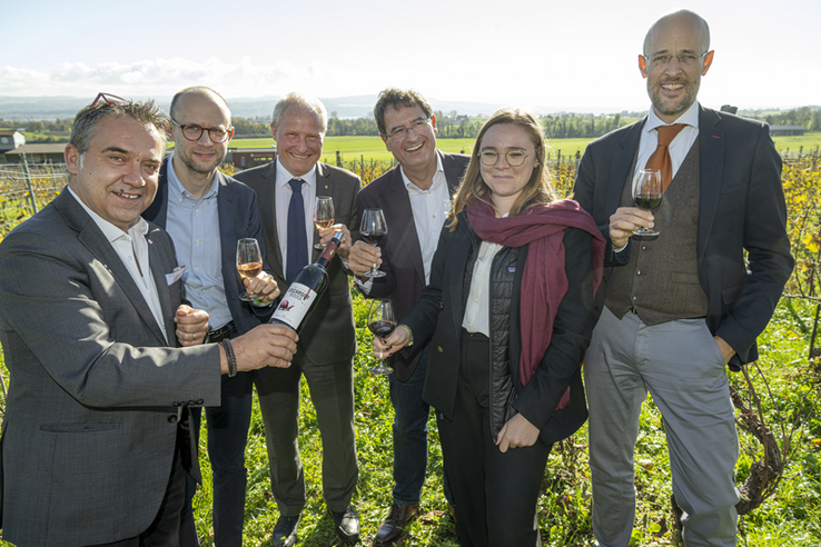 Les personnages dans une vigne, en train de déguster des verres de vin.