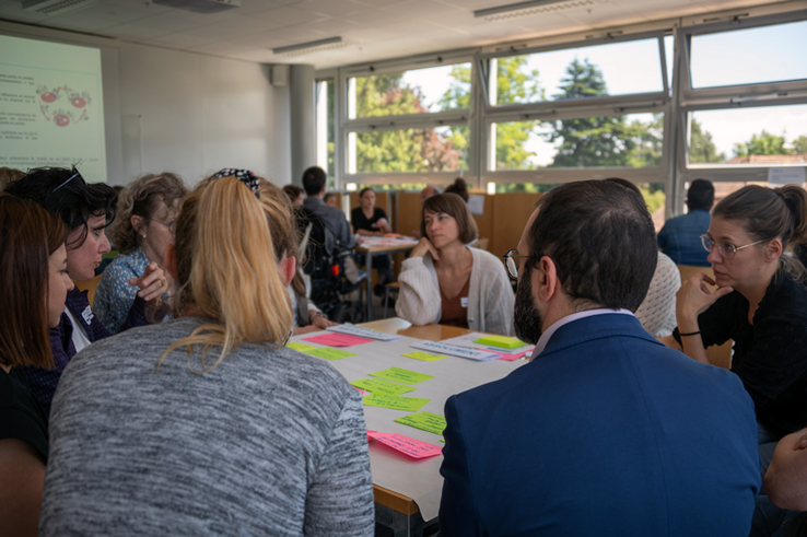 Groupe de personnes dans une salle, en discussion.