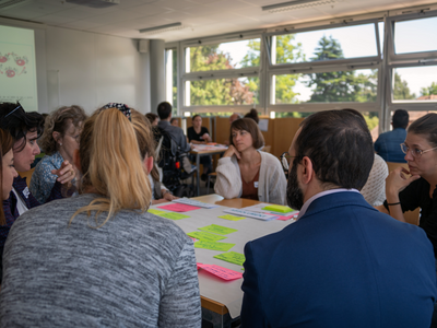 Groupe de personnes dans une salle, en discussion.