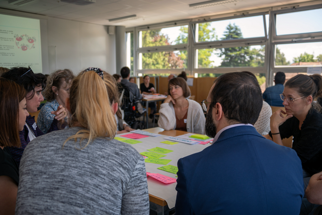 Groupe de personnes dans une salle, en discussion.