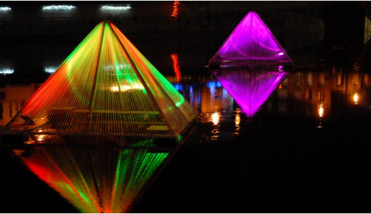 Des pyramides lumineuses apparaissant posées sur l'eau.