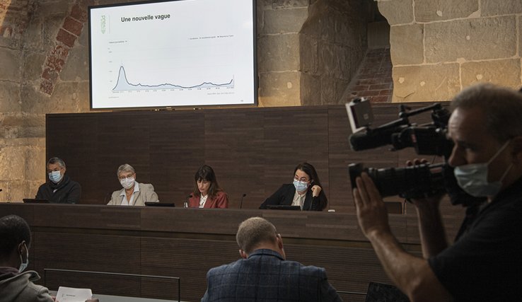 Le médecin cantonal, les conseillères d'Etat Béatrice Métraux, Rebecca Ruiz et Cesla Amarelle derrière leurs pupitres lors de la conférence de presse.