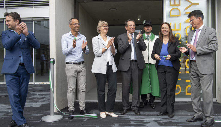 Représentantes et représentants des autorités devant l'entrée du gymnase au moment du traditionnel couper de ruban.