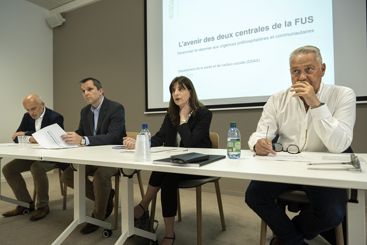 Les personnages assis, en conférence de presse.