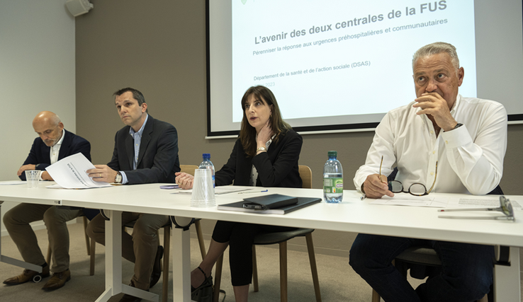 Les personnages assis, en conférence de presse.