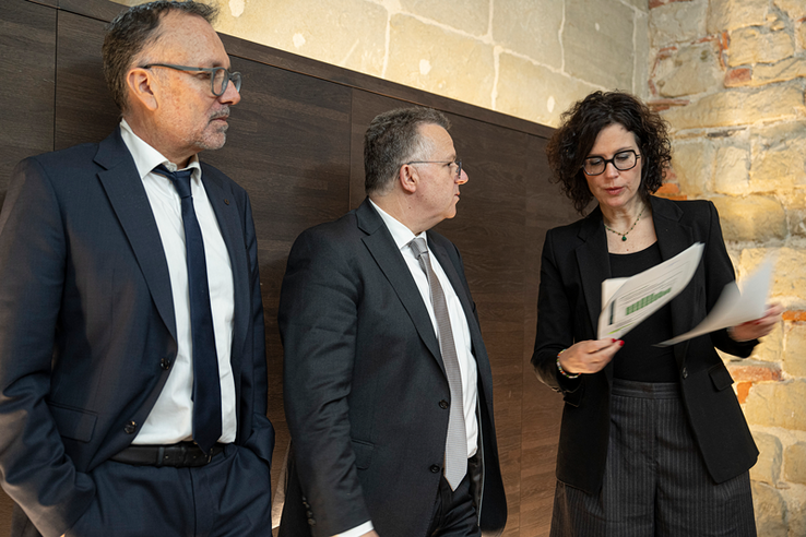 Les personnes après la conférence de presse. Madame Luisier tient un dossier de presse.