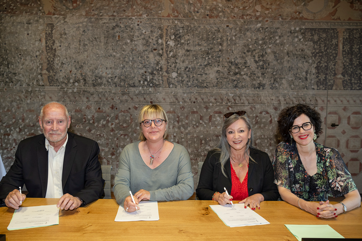 Les personnages derrière une table avec la convention signée.