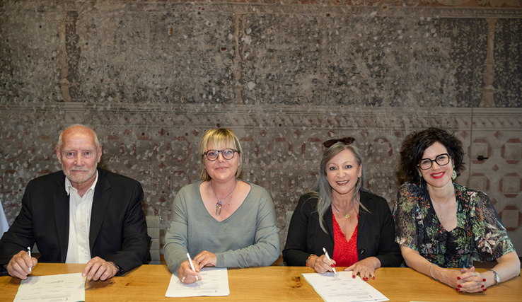 Les personnages derrière une table avec la convention signée.