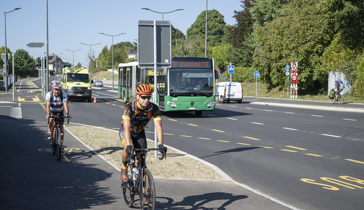 Vue du carrefour avec des cyclistes et un bus.