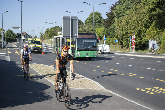 Vue du carrefour avec des cyclistes et un bus.