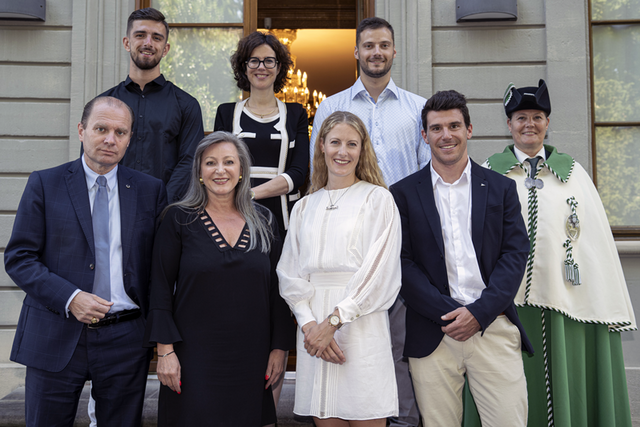 Les athlètes posent sur le perron de la Maison de l'Elysée en compagnie des membres du Conseil d'Etat et d'une huissière du Conseil d'Etat.