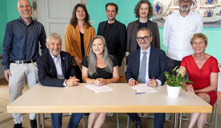 Photographie de groupe lors de la signature de la convention. Debout, de g. à d. : Boris Mury, secrétaire général de la Région de Nyon, Mélanie Courvoisier, directrice administrative et opérationnelle, Alexandre Démétriadès, municipal en charge de la culture, Émilie Bujès, directrice artistique, Pierre-François Umiglia, secrétaire municipal. Assis, de g. à d. : Daniel Rosselat, syndic, Nuria Gorrite, Raymond Loretan, président Visions du réel, Valérie Jeanrenaud, responsable politique de la culture et du sport à la Région de Nyon. Photo : ARC /JB Sieber