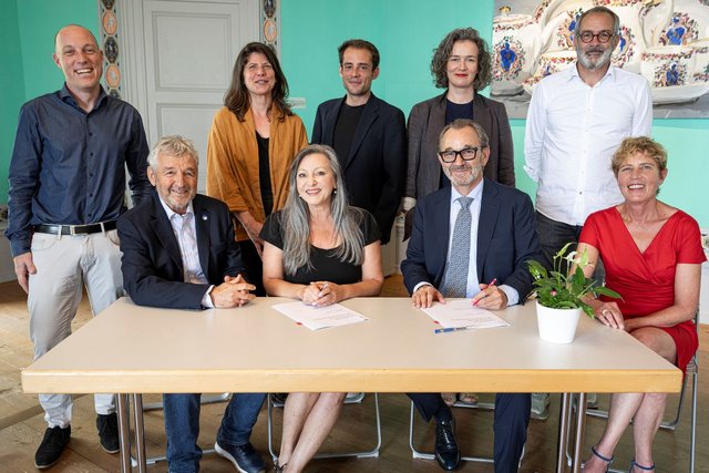 Photographie de groupe lors de la signature de la convention. Debout, de g. à d. : Boris Mury, secrétaire général de la Région de Nyon, Mélanie Courvoisier, directrice administrative et opérationnelle, Alexandre Démétriadès, municipal en charge de la culture, Émilie Bujès, directrice artistique, Pierre-François Umiglia, secrétaire municipal. Assis, de g. à d. : Daniel Rosselat, syndic, Nuria Gorrite, Raymond Loretan, président Visions du réel, Valérie Jeanrenaud, responsable politique de la culture et du sport à la Région de Nyon. Photo : ARC /JB Sieber