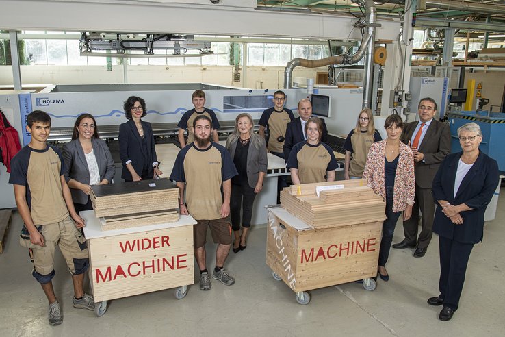 Apprentis et membres du Conseil d'Etat dans l'atelier de la menuiserie Wider.