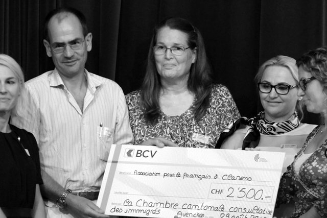 Roxanne Meyer Keller, présidente du jury, remet le "Prix du Milieu du Monde" aux membres de l'association pour le français à Clarens.