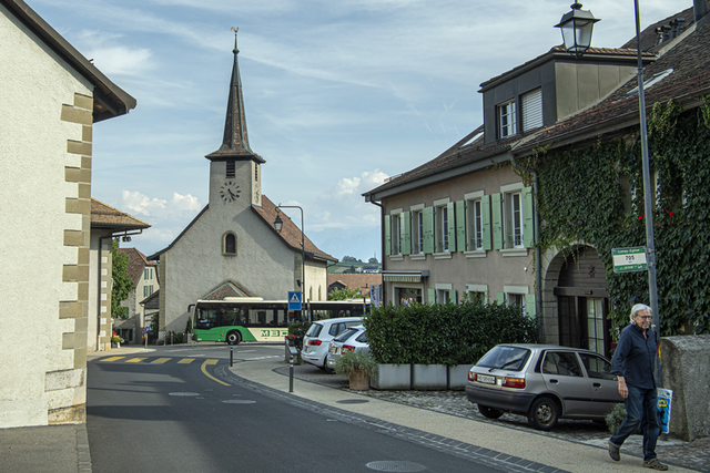 Vue du centre du village de Lonay, avec un passant et un bus