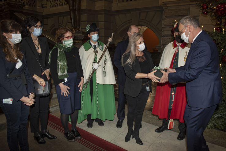 Le présidente du Conseil d'Etat Nuria Gorrite tend une boîte entourée d'un ruban au nouveau président de la Confédération.
