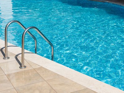 Clear turquoise water in the outdoor swimming pool and railings. egfer