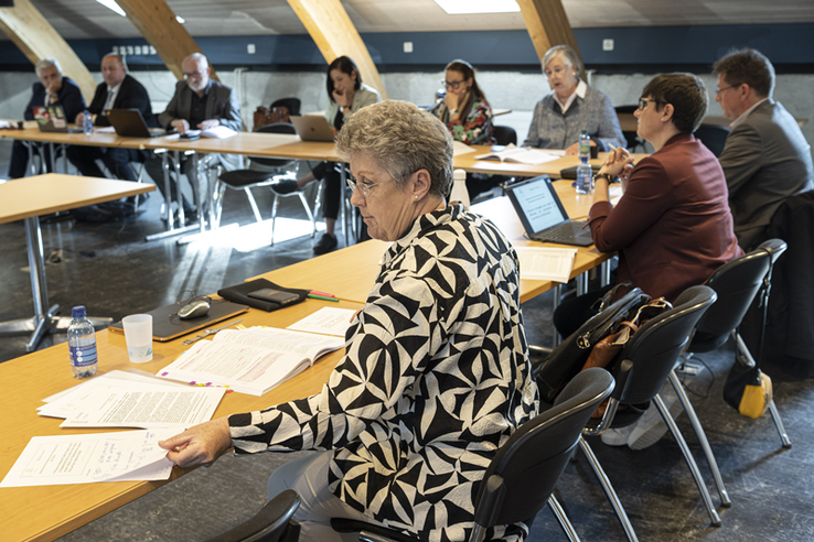 La présidente vue de trois-quarts consulte des documents devant elle. A sa gauche, d'autres membres de la commission, durant la conférence de presse.