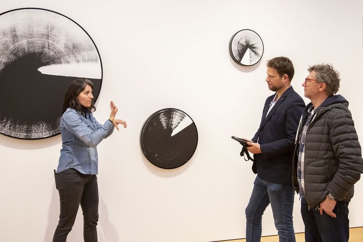 Photographie de 1) Noha El Sadawi, médiatrice culturelle sourde, présentant en langue des signes française une œuvre de l’exposition permanente du MCBA 