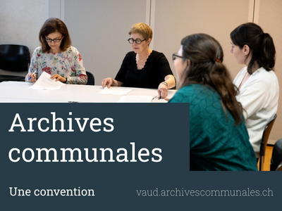 Plusieurs personnes autour d'une table, l'une d'elles tient les documents à signer.