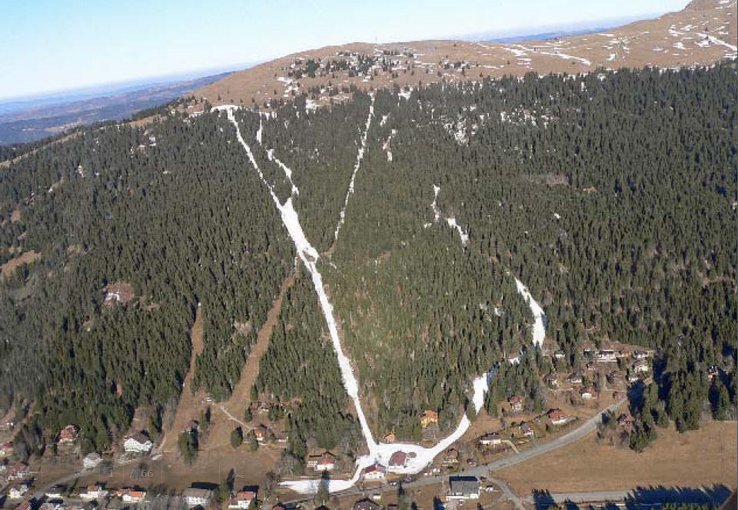 pistes de ski artificiellement enneigées sur une montagne sans neige.