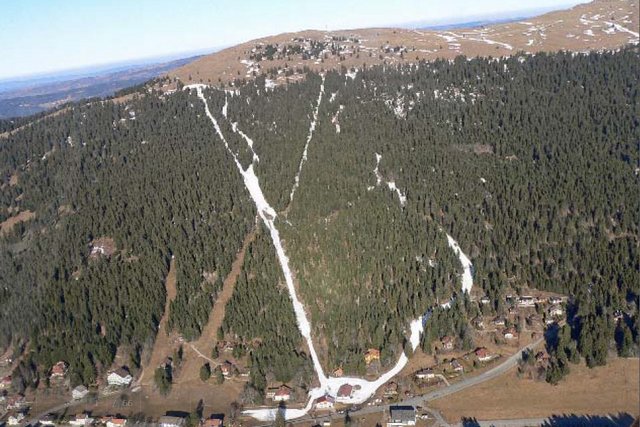 pistes de ski artificiellement enneigées sur une montagne sans neige.