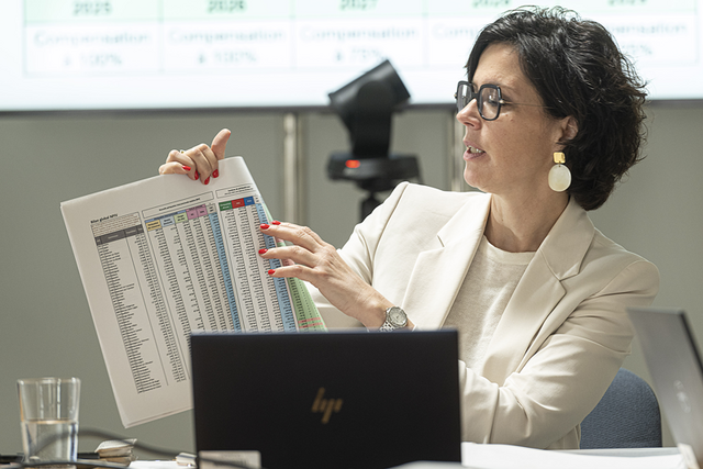 la conseillère d'Etat assise derrière son ordinateur consulte le document tableau qui détaille les effets financiers pour les communes.
