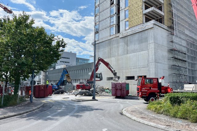 Vue de l'immeuble. Des engins évacuent des restes de l'échafaudage effondré.