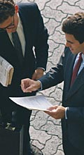 Sur une place publique, deux hommes d'affaires examinent un document écrit